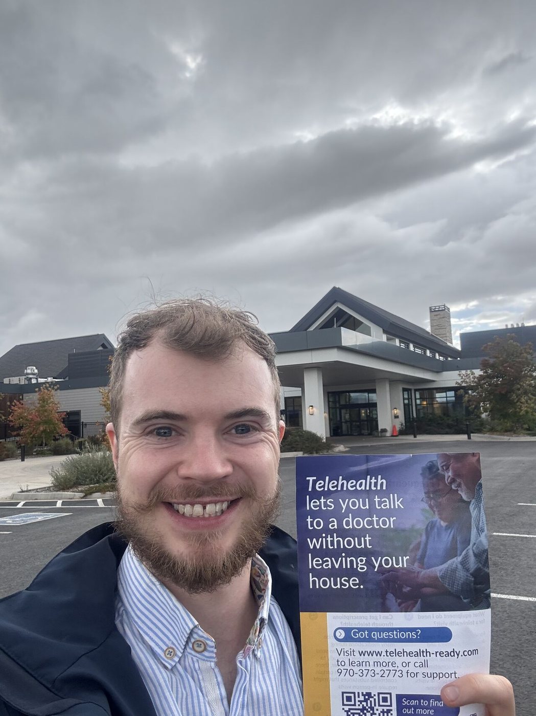 Applichat team member with a telehealth awareness flyer outside a rural Colorado clinic.