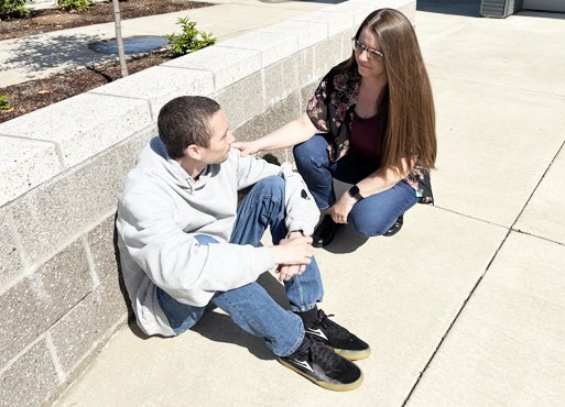 A peer support specialist talking with a community member outside.