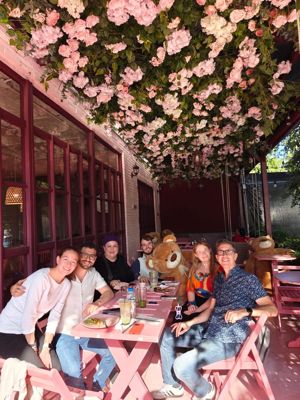 The team gathered for a meal under a canopy of flowers.